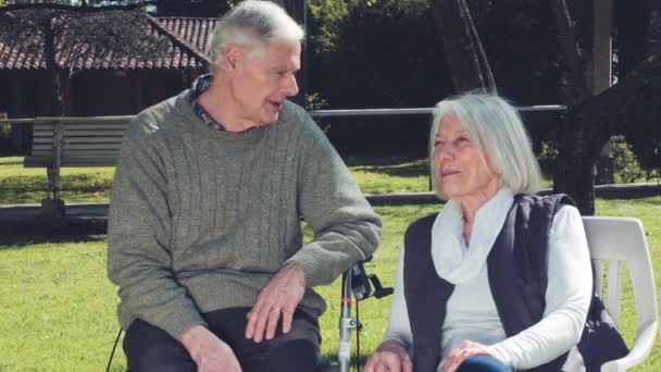 Elderly man and woman making aquaintance in hospital garden. Slow motion — Stock Video