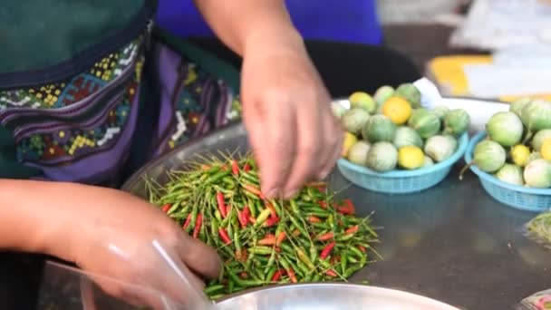 Vrouw snijden rode chili in een stad markt — Stockvideo