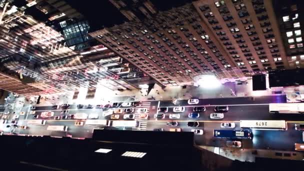 Vista aérea hacia abajo del tráfico callejero de Manhattan por la noche desde la cima de una torre de la ciudad — Vídeos de Stock