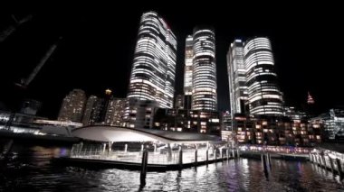 Hareket halindeki bir tekneden Barangaroo gökdelenlerinin gece görüşü, Sydney