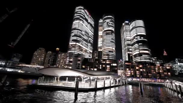 Vista nocturna de los rascacielos Barangaroo desde un barco en movimiento, Sydney — Vídeo de stock