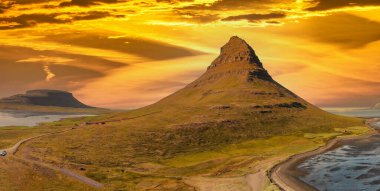 İzlanda 'da gün batımında Kirkjufell dağ manzarasının hava panoramik görüntüsü, insansız hava aracı bakış açısı.