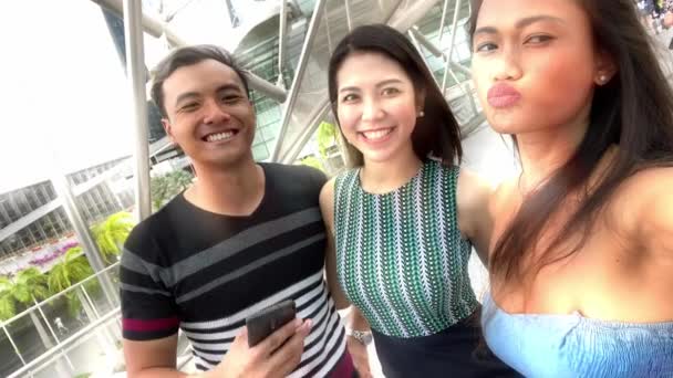 Tres amigos asiáticos disfrutando de la vida al aire libre de la ciudad, tomando selfies y haciendo muecas a la cámara. Concepto de amistad y vacaciones — Vídeo de stock