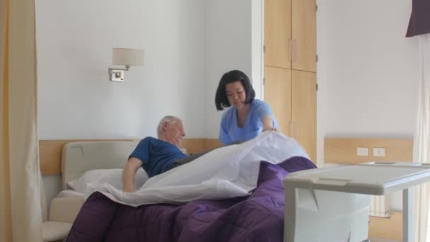 Zeitlupe von asiatisch weiblich doktor help älter mann aufstehen aus bett im die krankenhaus — Stockvideo