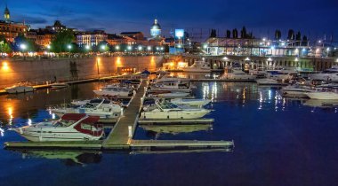 Montreal geceleri, Kanada. Gün batımında şehir limanı ve binalar.