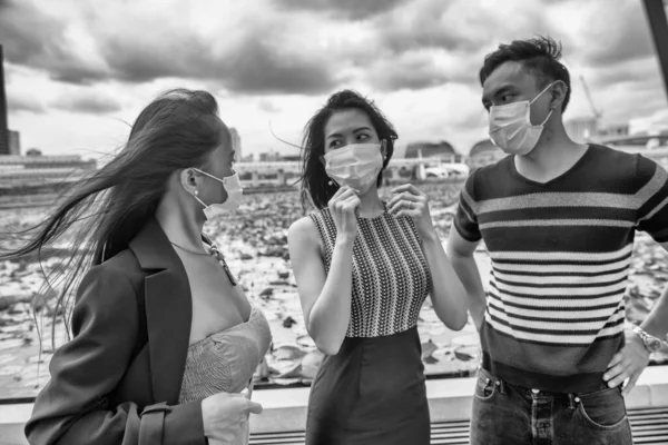 三位快乐的年轻亚洲朋友戴着口罩在户外预防眼镜蛇大流行 — 图库照片