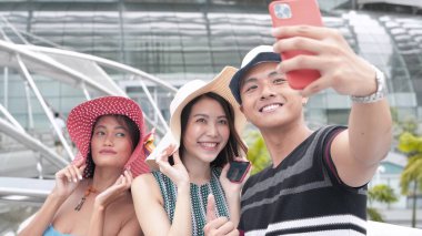 Üç Asyalı arkadaş şehirde selfie çekiyorlar. Mutluluk ve turizm kavramı.