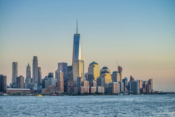 Amazing sunset colors of Lower Manhattan skyline from the ferry boat, New York City.