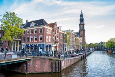 AMSTERDAM, NETHERLANDS - 25 Nisan 2015: Kanal üzerindeki geleneksel evler ve binalar.