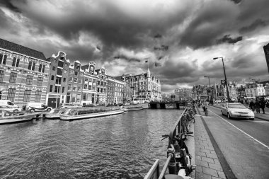 AMSTERDAM, NETHERLANDS - 25 NİSAN 2015: Kanalda tekneli geleneksel evler ve binalar.