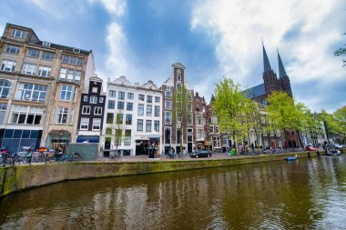 AMSTERDAM, NETHERLANDS - 25 Nisan 2015: Kanal üzerindeki geleneksel evler ve binalar.
