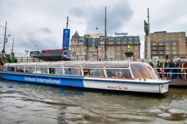 AMSTERDAM, NETHERLANDS - 25 NİSAN 2015: Kanalda tekneli geleneksel evler ve binalar.