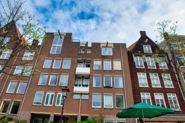 AMSTERDAM, NETHERLANDS - 25 Nisan 2015: Kanal üzerindeki geleneksel evler ve binalar.