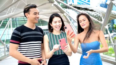 Üç Asyalı genç arkadaş yeni bir şehri gezmenin keyfini çıkarıyorlar..