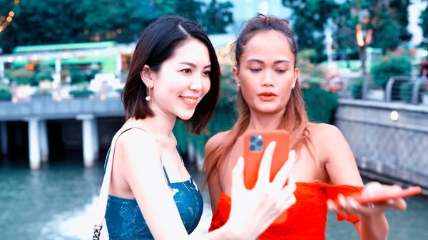 2人の美しい若いアジアの女性が話して 笑顔で 街の通りを歩いてリラックスし 彼らのスマートフォンを見て — ストック写真