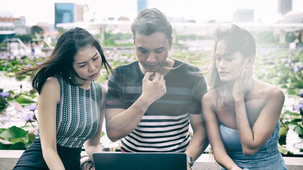 Трое Азиатских Молодых Друзей Сидят Скамейке Смотрят Ноутбуке — стоковое фото