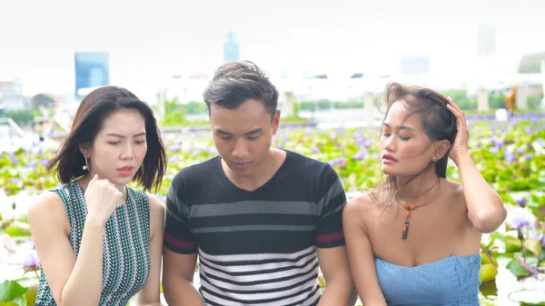 Trois Jeunes Amis Asiatiques Assis Sur Banc Regardant Quelque Chose — Photo