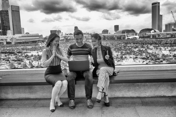 Τρεις Χαρούμενοι Νεαροί Ασιάτες Φίλοι Κάθονται Ένα Δημόσιο Παγκάκι Αγοράζοντας — Φωτογραφία Αρχείου