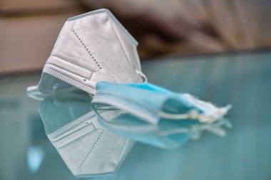 Masada koruyucu maskeler var. Cerrahi ve N95 yansımaları.