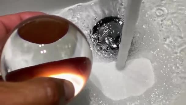Transparent ball with flowing faucet water, slow motion — Stock Video