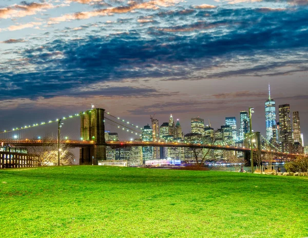 Brooklynský Most Při Západu Slunce Siluetou Manhattanu Pozadí Zelenou Loukou — Stock fotografie