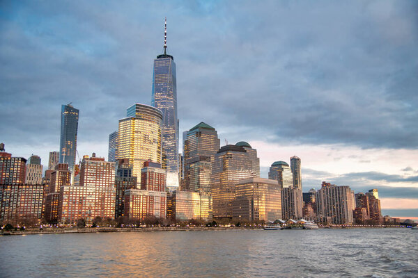 Sunset view of Downtown Manhattan skyline from ferry boat, New York City