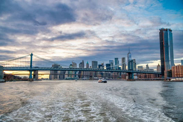 フェリーからマンハッタンのスカイラインとマンハッタン橋の夕景 — ストック写真