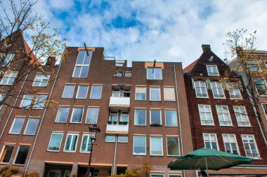 AMSTERDAM, NETHERLANDS - 25 Nisan 2015: Kanal üzerindeki geleneksel evler ve binalar.