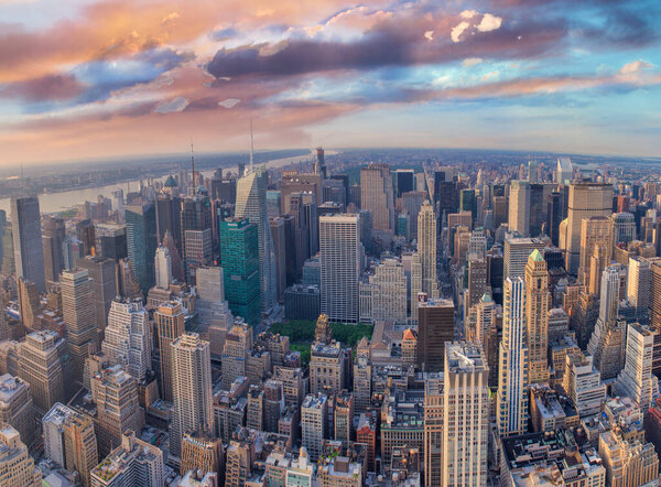 NEW YORK CITY - JUNE 10, 2013: Panoramic aerial view of Manhattan from a city rooftop at sunset.