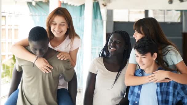 Grupo de adolescentes de raza mixta colgando y sonriendo en el pasillo de la escuela, rayos de luz que vienen del cielo — Vídeos de Stock