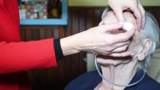 Γυναίκα στάζει σταγόνες στα μάτια ενός ηλικιωμένου ασθενούς με ρινογαστρική διασωλήνωση κατά τη διάρκεια μιας θεραπείας στο σπίτι — Αρχείο Βίντεο