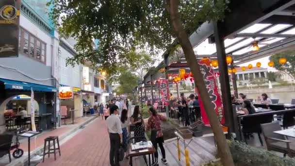 SINGAPUR - 31. Dezember 2019: Touristen genießen die Flusspromenade bei Sonnenuntergang — Stockvideo