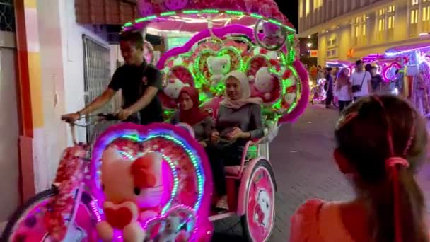 MALACCA, MALAYSIA - DECEMBER 29, 2019: Туристи вночі насолоджуються освітленими тукаками — стокове відео