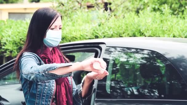 Donna che prende la spesa dalla sua auto disinfettando le mani e indossando maschera da coronavirus emergenza — Video Stock