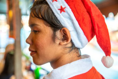 AMPHAWA, THAILAND - DECEMBER 15, 2019: Thailand woman wears red hat in the famous floating market.