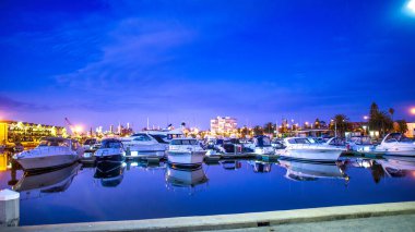 St. KILDA, AUSTRALYA - Kasım 2015: Gün batımında kenetlenmiş tekneleri olan şehir limanı.