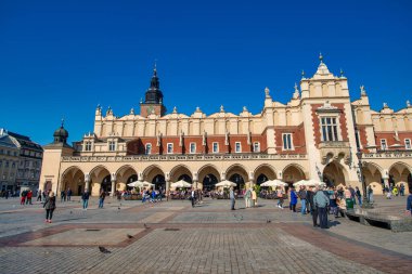 KRAKOW, POLAND - 1 Ekim 2017: Turistler güneşli bir günde ana ortaçağ meydanını ziyaret ettiler
