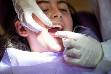 Diş teli takmak dişçi stüdyosundaki küçük tatlı bir kıza..