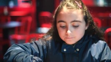 Restoranda hamburger yiyen genç bir kız.