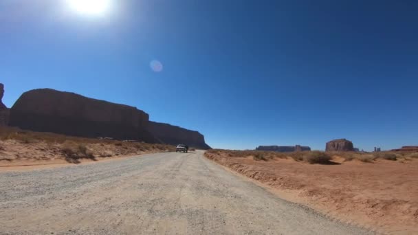 MONUMENT VALLEY, USA - JULI 2019: Het oversteken van de Canyon in het zomerseizoen, uitzicht vanaf de voorkant van de auto Slow motion — Stockvideo