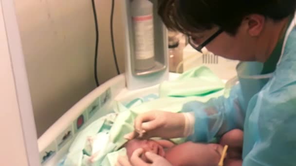 Lekarz pediatra badający oczy dziecka w klinice, noworodka — Wideo stockowe