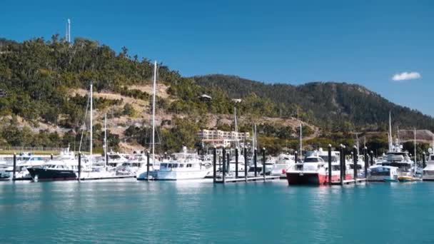 AIRLIE BEACH, ÖSTERRIKE - AUGUSTI 2018: Utsikt över stadshamnen sett utifrån en rörlig båt — Stockvideo