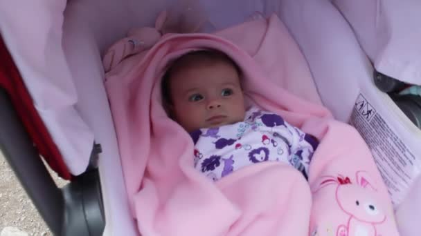 Bebek hareket ediyor ve bebek arabasında yatarken komik yüz ifadeleri takınıyor. — Stok video