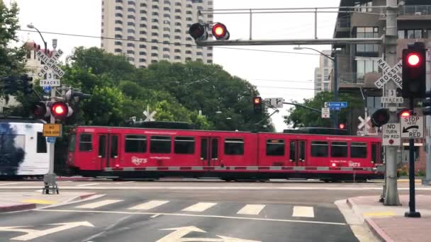 SAN DIEGO, CA - AĞUSTOS 2017: Seviye geçişi ile şehir caddelerini geçen gerçek tramvay — Stok video