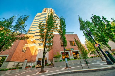 PORTLAND, OR - 21 AĞUSTOS 2017: Güneşli bir günde şehir binaları ve ağaçları.