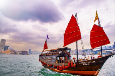 HONG KONG - Mayıs 2014: Bulutlu bir günde turist yelkenlisi Aqua Luna ile şehir silueti. Victoria Limanı 'ndan görünüm.
