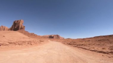 Yaz mevsiminde Mounument Vadisi 'ni geçerken, arabanın önünden manzara...