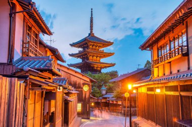 Antik Budist tapınağı Hokan-ji eski Kyoto kasabasında gecenin erken saatlerinde. Mavi parlayan gökyüzü geleneksel pagoda ile çelişiyor.