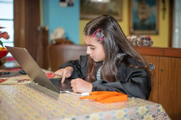年轻女孩在笔记本电脑的帮助下做作业 — 图库照片