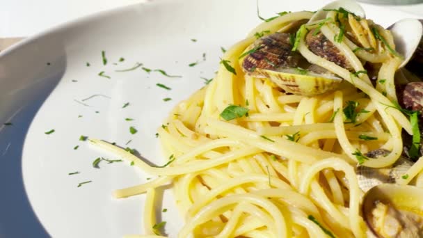 Вкусные спагетти с моллюсками на столе, замедленная съемка — стоковое видео